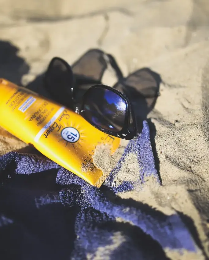 Sunblock Sunglass on beach sand